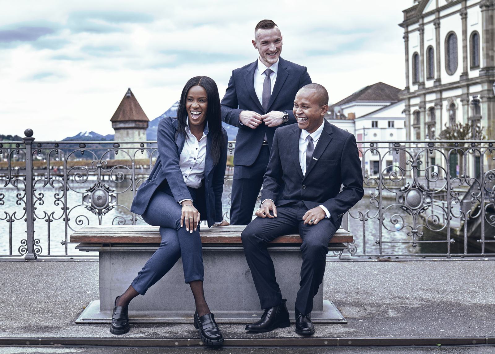 Three BHMS students in business suits standing by the Lucerne waterfront