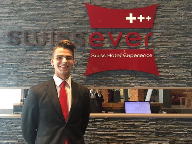 BHMS student behind a Swiss hotel reception desk during an internship placement